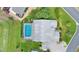 Aerial view of the home with a screened-in pool, gray roof, and lush green landscaping at 5660 Sandpipers Dr, Lakeland, FL 33809