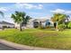 Inviting home exterior with lush green lawn, swaying palms, and covered windows that add a touch of elegance at 5660 Sandpipers Dr, Lakeland, FL 33809