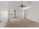 A carpeted main bedroom features a ceiling fan and sliding glass doors that lead to the pool at 5660 Sandpipers Dr, Lakeland, FL 33809