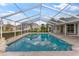 Screened-in pool with sky reflection offers a private and refreshing outdoor experience at 5660 Sandpipers Dr, Lakeland, FL 33809