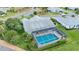 Aerial view of the caged pool and backyard of this charming home, surrounded by lush landscaping at 5660 Sandpipers Dr, Lakeland, FL 33809