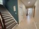 Inviting hallway featuring tiled floors, a staircase, and an archway leading to the front door at 124 Magneta Loop, Auburndale, FL 33823