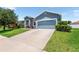 A long driveway leading to an attached 2-car garage on a home with a well-manicured lawn at 192 Viola Dr, Auburndale, FL 33823