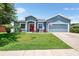 Charming single-story home with well-maintained lawn, classic columns, and a bright red front door at 192 Viola Dr, Auburndale, FL 33823