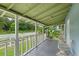 Relaxing front porch with white railing overlooking a tree-lined street at 954 Reynolds Rd, Lakeland, FL 33801