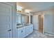 Bathroom boasts double sinks with granite counters, bright vanity lighting, and walk-in closet access at 4039 Tullamore Ln, Auburndale, FL 33823