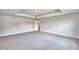 Spacious bedroom features plush carpet flooring, neutral paint, and a tray ceiling at 4039 Tullamore Ln, Auburndale, FL 33823