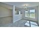 Bright dining room with a modern chandelier and large window overlooking the yard at 4039 Tullamore Ln, Auburndale, FL 33823