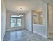 Bright dining room with modern chandelier, large window, and neutral tile flooring at 4039 Tullamore Ln, Auburndale, FL 33823