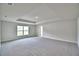 Large main bedroom with tray ceiling, a large window, and neutral carpeting at 4039 Tullamore Ln, Auburndale, FL 33823