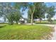 House exterior showing a light-blue home nestled among large trees, overlooking a lake at 420 W Gates Ave, Lake Hamilton, FL 33851