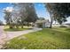 Exterior view of a light-blue house with a circular driveway and lush green lawn at 420 W Gates Ave, Lake Hamilton, FL 33851