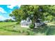 Rustic light green house with sunroom nestled amongst large trees at 420 W Gates Ave, Lake Hamilton, FL 33851