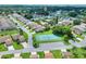 Aerial view of a residential community with lush landscaping, mature trees, and a tennis court at 4420 Glenns Lndg, Winter Haven, FL 33884