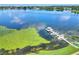 Scenic lake view featuring a dock with a gazebo and boats, set against a clear blue sky with lily pads at 4420 Glenns Lndg, Winter Haven, FL 33884