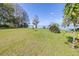 Backyard with green grass lawn, trees and view of lake beyond the property at 9650 W Lake Marion Rd, Haines City, FL 33844