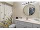 Bathroom with a shower/tub combo, white vanity, and round mirror at 1521 Oakview Se Cir, Winter Haven, FL 33880