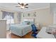 Bright bedroom with a light blue comforter, ceiling fan, and built-in desk at 1521 Oakview Se Cir, Winter Haven, FL 33880