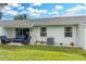 Rear view of the home showcasing a patio and a well-maintained lawn at 1521 Oakview Se Cir, Winter Haven, FL 33880