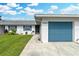 Front view of a single story home with a blue garage door and landscaped lawn at 1521 Oakview Se Cir, Winter Haven, FL 33880