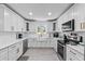 Modern white kitchen with a farmhouse sink and stainless steel appliances at 222 Rod Ln, Davenport, FL 33837