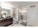 Bathroom with double vanity, walk-in shower, and dark wood cabinets at 605 Sarner Pass Way, Winter Haven, FL 33881