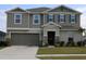 Two story house with gray siding and stone accents at 605 Sarner Pass Way, Winter Haven, FL 33881