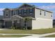 Two-story house with gray siding, stone accents, and landscaping at 605 Sarner Pass Way, Winter Haven, FL 33881