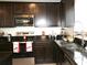 Modern kitchen with dark wood cabinets and granite countertops at 605 Sarner Pass Way, Winter Haven, FL 33881