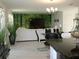 Open living area showcasing a large TV and forest mural, creating a relaxing atmosphere at 605 Sarner Pass Way, Winter Haven, FL 33881