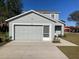 Two-story house with gray siding, attached garage, and landscaping at 1300 Lucerne Loop Ne Rd, Winter Haven, FL 33881