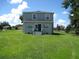 Two-story house back view, featuring a spacious yard and sliding glass doors at 1300 Lucerne Loop Ne Rd, Winter Haven, FL 33881