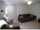 Cozy living room featuring a brown couch, entryway, and ceiling fan at 1300 Lucerne Loop Ne Rd, Winter Haven, FL 33881