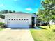 Inviting single-story home with a two car garage, decorative fountain, and luscious landscaping at 2158 Mirasol Dr, Winter Haven, FL 33881