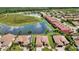 Aerial view of townhomes next to a pond with mature trees and manicured lawns at 1202 Ashton Palms Dr # 6, Lake Wales, FL 33859