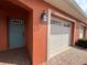 Inviting home exterior with a charming teal door and well-maintained garage at 1202 Ashton Palms Dr # 6, Lake Wales, FL 33859