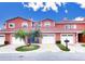 Charming two-story townhome featuring a brick driveway, private garages, and tropical landscaping at 1202 Ashton Palms Dr # 6, Lake Wales, FL 33859