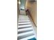 Well-lit staircase with painted white steps and a wooden handrail at 1202 Ashton Palms Dr # 6, Lake Wales, FL 33859
