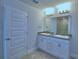 Bright bathroom features double sinks with granite counters and a glass shower door at 1476 Leamington Lane, Winter Haven, FL 33884