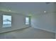 Neutral bedroom boasts carpet flooring and dual windows, creating a bright and airy space at 1476 Leamington Lane, Winter Haven, FL 33884