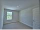 Bright bedroom featuring a window, neutral carpet, and a white door at 1476 Leamington Lane, Winter Haven, FL 33884