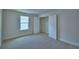 Neutral bedroom with carpet, a window with blinds and closet with a bi-fold door and shelving at 1476 Leamington Lane, Winter Haven, FL 33884