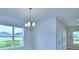 Dining room features modern chandelier, large windows, and neutral decor at 1476 Leamington Lane, Winter Haven, FL 33884