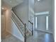 Bright foyer boasts soaring ceilings, a staircase with wood handrail, neutral decor and decorative tile flooring at 1476 Leamington Lane, Winter Haven, FL 33884