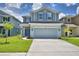 Charming two-story home with a two car garage, gray siding and blue shutters and manicured front lawn at 1476 Leamington Lane, Winter Haven, FL 33884