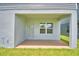 This covered patio features a door to the house and a large window providing lots of natural light at 1476 Leamington Lane, Winter Haven, FL 33884