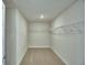 Spacious walk-in closet features carpet flooring, wire shelving, and ample space for storage at 1476 Leamington Lane, Winter Haven, FL 33884