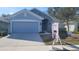 Two-story home with light blue exterior, stone accents, and a two-car garage at 296 Krenson Bay Loop, Winter Haven, FL 33881