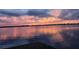 Beautiful sunset reflecting on calm lake waters near a dock at 3537 Julius Estates Blvd, Winter Haven, FL 33881