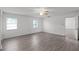 Large bedroom with wood-look floors, ceiling fan and access to another room at 405 W 4Th Ct, Frostproof, FL 33843